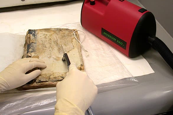 Vacuuming mould from damaged book